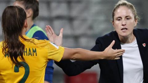 Wales coach Gemma Grainger shakes hands with Lily Woodham after the match