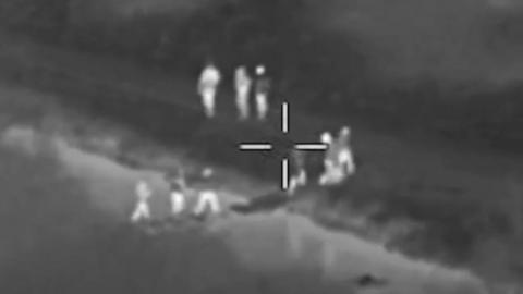Footage shows people crossing a river to leave the scene