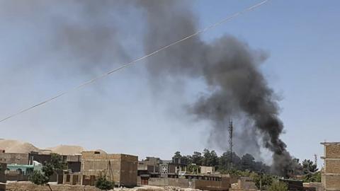 Smoke rises from houses during fighting in Qala-e- Naw, the capital of Badghis province, on July 7, 2021