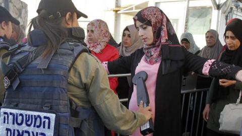 Israeli border policewoman scans Palestinian at West Bank checkpoint (file photo)