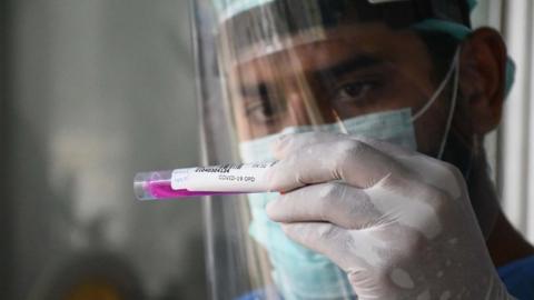 A health official takes a swab sample from a woman to test for the COVID-19 testing facility at a hospital in Karachi, Pakistan on April 30, 2021.