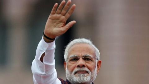 India"s Prime Minister Narendra Modi waves to his supporters as he arrives to address them during an election campaign meeting ahead of Gujarat state assembly elections, in Ahmedabad, India, December 3, 2017.