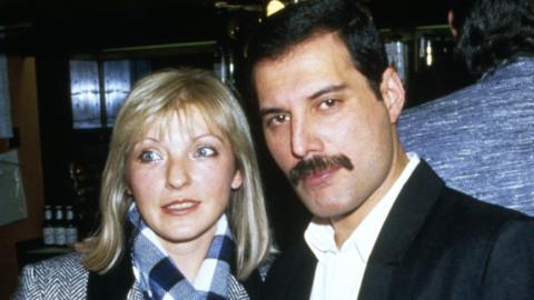 Singer Freddie Mercury of Queen attends Fashion Aid at the Royal Albert Hall in London, with his friend Mary Austin, 5th November 1985.