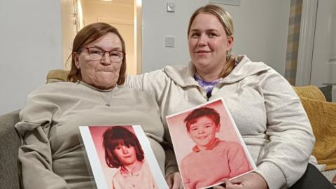 Liz McMonigle and her daughter Kim Kellacher holding pictures of Irene and John McMonigle