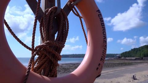 close up of a life preserver in front of a beach