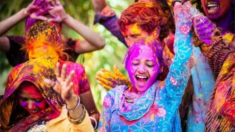 Indian Friends Dancing Covered on Holi colorful powder in India