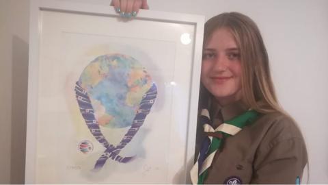 Charlie, 15 displaying her World Scout Jamboree logo design