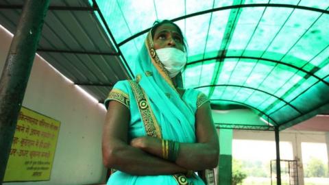 Relative of a patient suffering from Tuberculosis standing outside of a government hospital.