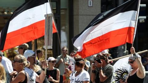 Protesters carry the flag of the pre-World War One German Empire at the Berlin protest