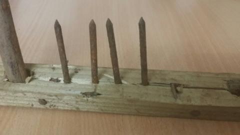 A picture of a plank with nails