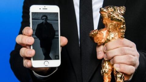 A photo of Mohammad Rasoulof is shown on a mobile next to the Golden Bear