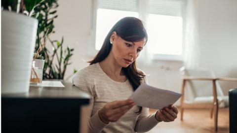 A woman reads a letter