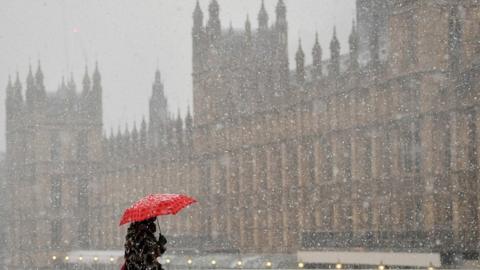 Woman crossing Westminster Bridge during snowstorm last month