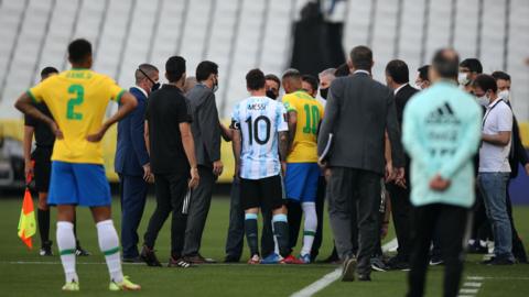 Lionel Messi and Neymar talk with officials after Brazil v Argentina is abandoned