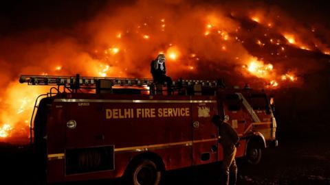 A fire engine at the flaming Bhalswa landfill site