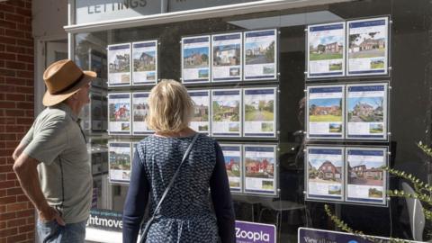 Couple looking at estate agent window