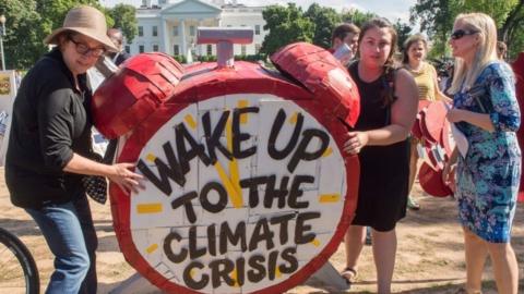 Protesters hold up signs during a demonstration in front of the White House in Washington, DC on June 1, 2017, objecting to US President Donald Trump"s decision to withdraw from the Paris Climate accord.