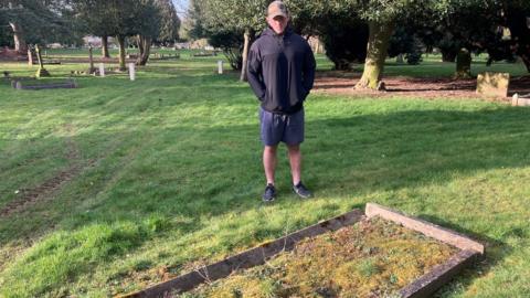 Alex Waller at the grave of Jim Barker