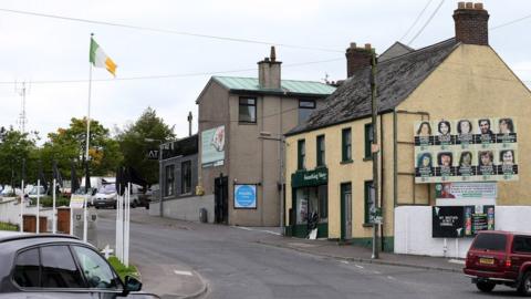 An Irish tricolour flies from a flagpole in Crossmaglen