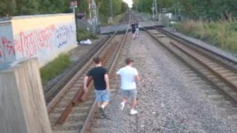 Children running along railway lines