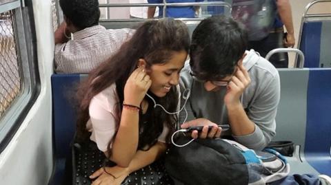 A couple watching and listening to video on a mobile phone