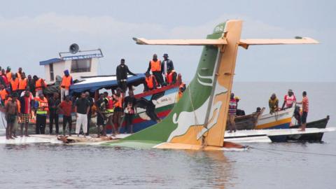 Rescue workers around the submerged plane