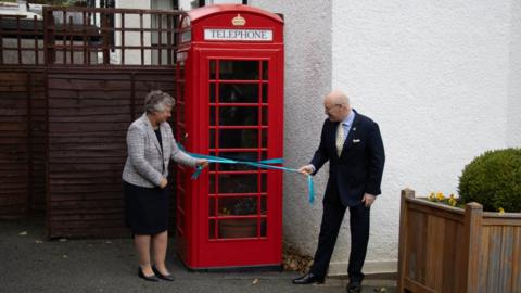 Sir John Lorimer and Lady Lorimer unveiling the restored telephone box