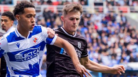 Ben Elliott of Reading and Mark Helm of Burton Albion battle for the ball