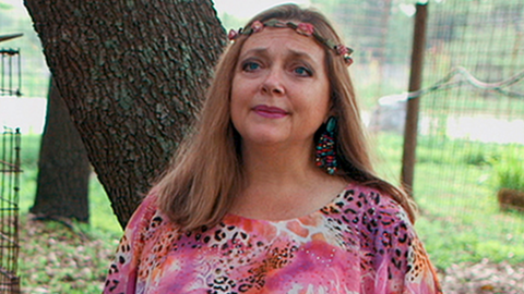 Carole Baskin and a lion in a cage