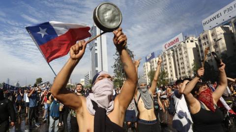 Demonstrators display flags and banners during a protest against President Sebastian Piñera on October 21, 2019 in Santiago, Chile