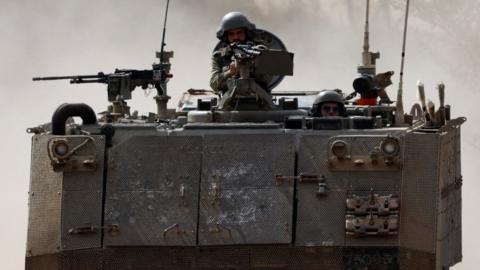 Israeli soldiers ride in an armoured personnel carrier (APC), amid the ongoing conflict between Israel and Hamas, near the border between Israel and Gaza Strip, in Israel