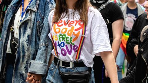 A woman at a gay pride march in Munich wears a T-shirt reading "everybody is free to love", 13 July 2019