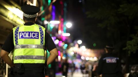 A police officer standing in a street in Manchester