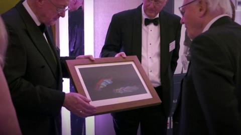 Sir David Attenborough presented with picture of fossil