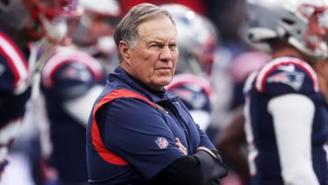 New England Patriots head coach Bill Belichick stands on the sideline with his arms folded