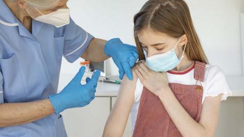 Girl being vaccinated by nurse