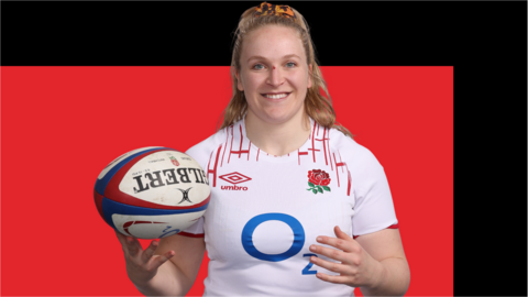 Liz Crake smiles as she spins a rugby ball on her hand