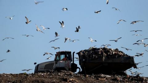 A vehicle collects garbage at the Walleys Quarry landfill in Silverdale village