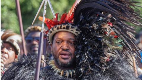 King of Amazulu nation Misuzulu kaZwelithini (C) holds a spear as he sings with Amabutho (Zulu regiments) during his coronation at the KwaKhangelamankengane Royal Palace in Kwa-Nongoma 300km north of Durban on August 20, 2022.