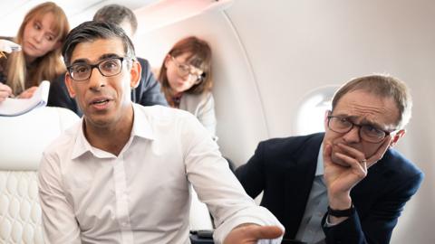 British Prime Minister Rishi Sunak holds a huddle with political journalists on board a government plane as he heads to Japan to attend the G7 summit in Hiroshima on 17 May 2023