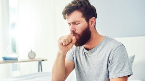 A man coughing