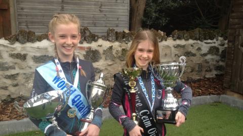 Dancing sisters Ffion and Abigael holding some of their many trophies