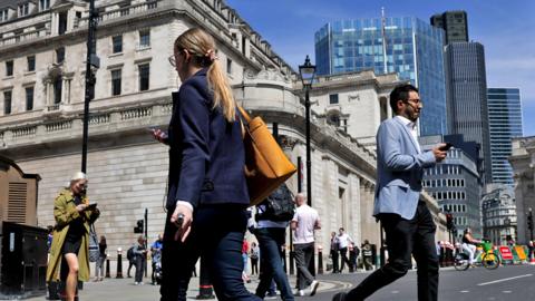 Commuters cross a junction near the Bank of England in the City of London, UK, on 8 May 2024