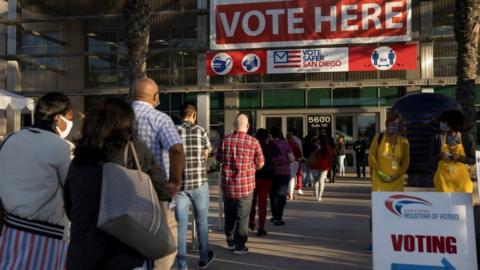 Poll workers wait in line to grab breakfast prior to the polls opening at the Registrar of Voters on the day of the U.S. Presidential election in San Diego, California