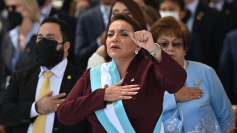 Honduran president-elect Xiomara Castro holds up her clenched fist as she wears the presidential sash after swearing in during her inauguration ceremony, in Tegucigalpa, on January 27, 2022.