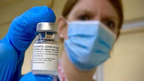 Nurse holding vaccine bottle