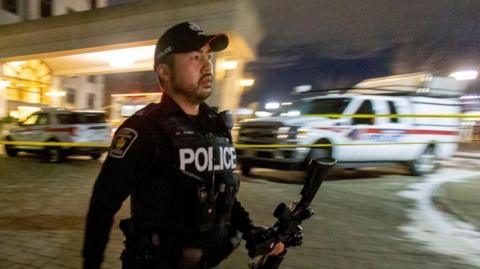 A police officer patrols the scene of a mass shooting in Toronto, Canada