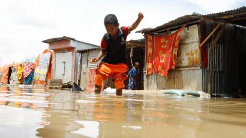 Boy wades through floodwaters at an IDP camp in Mogadishu