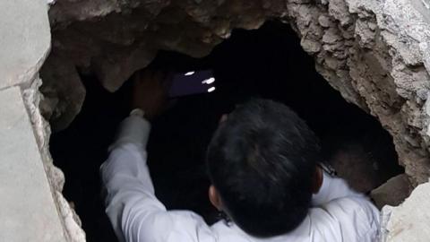 A man peers into the 25ft tunnel