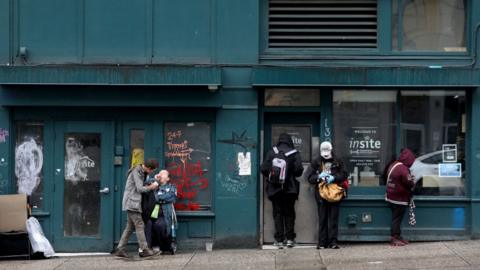 Clients wait outside of Insite, a supervised consumption site located in the Downtown Eastside